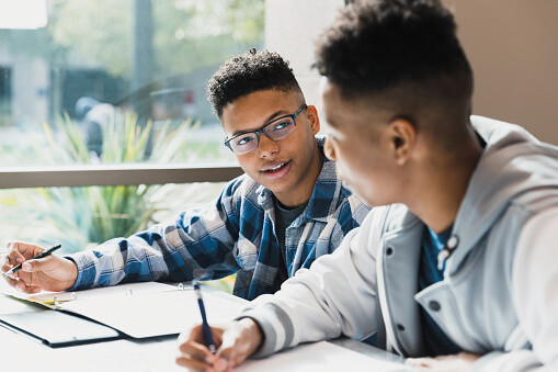 A Teenage Boy Talks To His Friend As They Study For A Test Together.