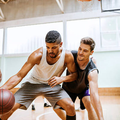 Close Up For Friends Playing Basketball At A Gymnasium